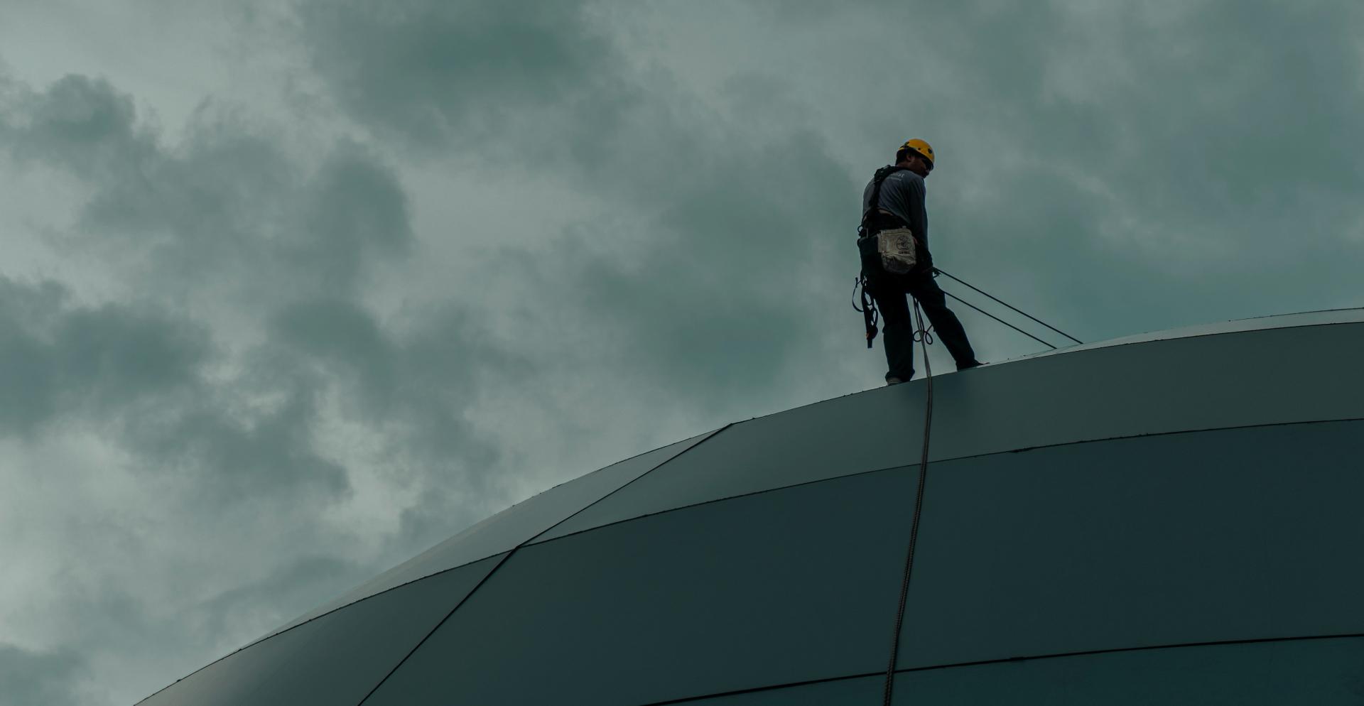 Werkman op dak Een man op een dak.